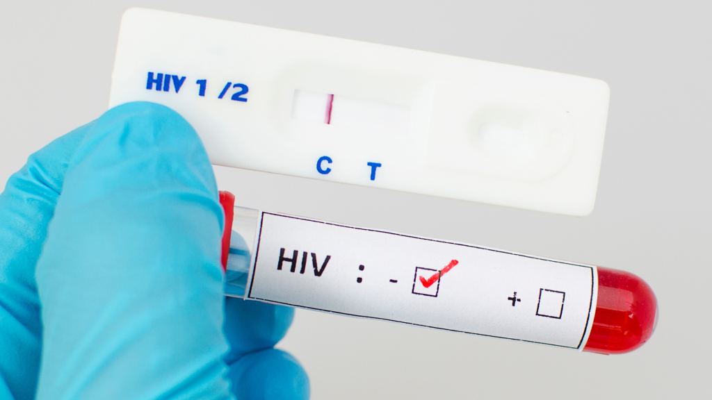 ภาพเจ้าหน้าที่สวมถุงมือถือตลับตรวจ HIV และหลอดเก็บตัวอย่างเลือดที่ระบุผลตรวจเป็นลบ